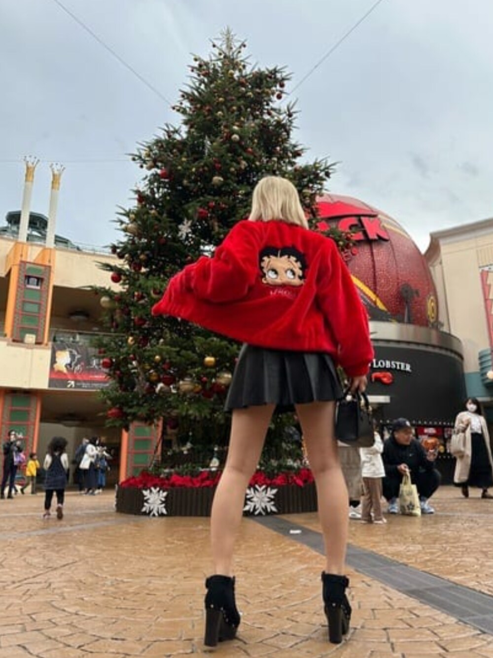 レッド系のその他アウター、ホワイト系のTシャツ/カットソー、ブラック系のスカートを着用したレディースの冬コーディネートの1枚目の写真