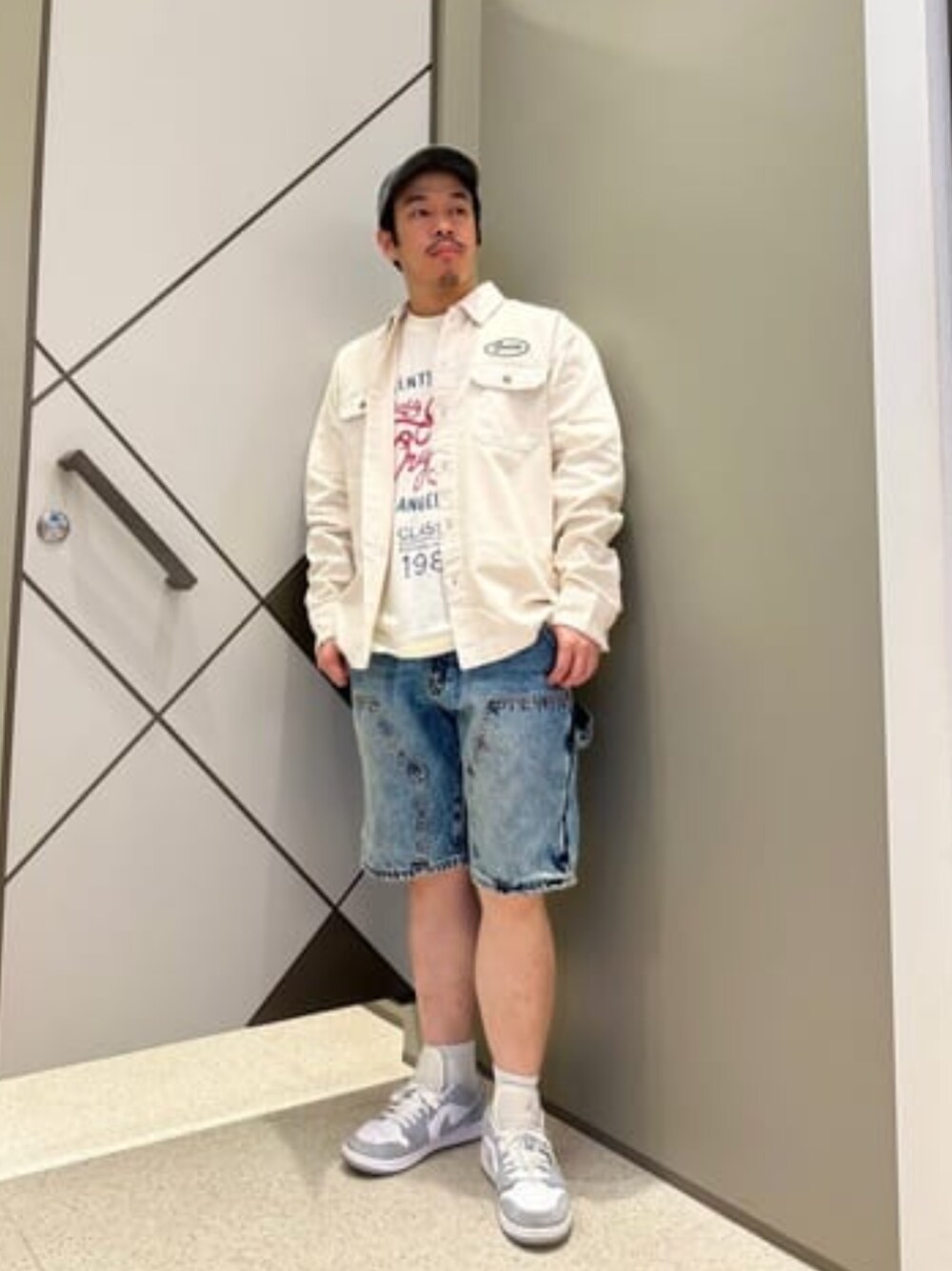 ホワイト系のTシャツ/カットソー、ブルー系のデニムパンツ、ホワイト系のブルゾンを着用したメンズの冬コーディネートの1枚目の写真