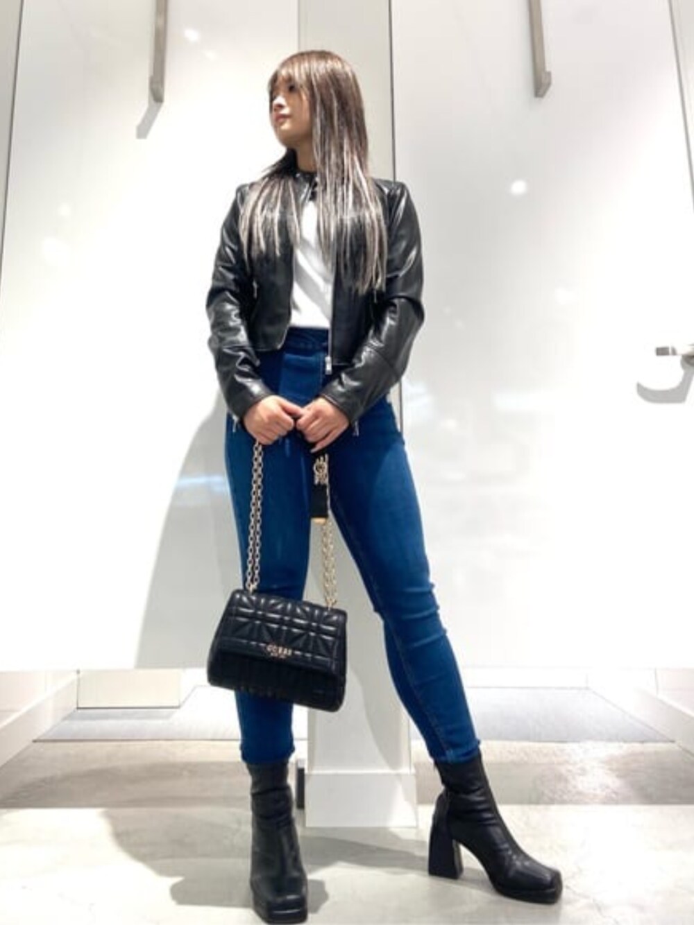 ブラック系のライダースジャケット、ホワイト系のTシャツ/カットソー、ブルー系のデニムパンツを着用したレディースの春コーディネートの1枚目の写真