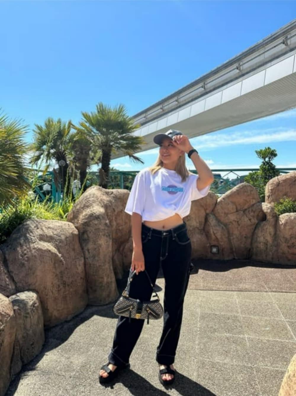 ブラック系のショルダーバッグ、ホワイト系のTシャツ/カットソー、グレー系のキャップを着用したレディースの秋コーディネートの1枚目の写真