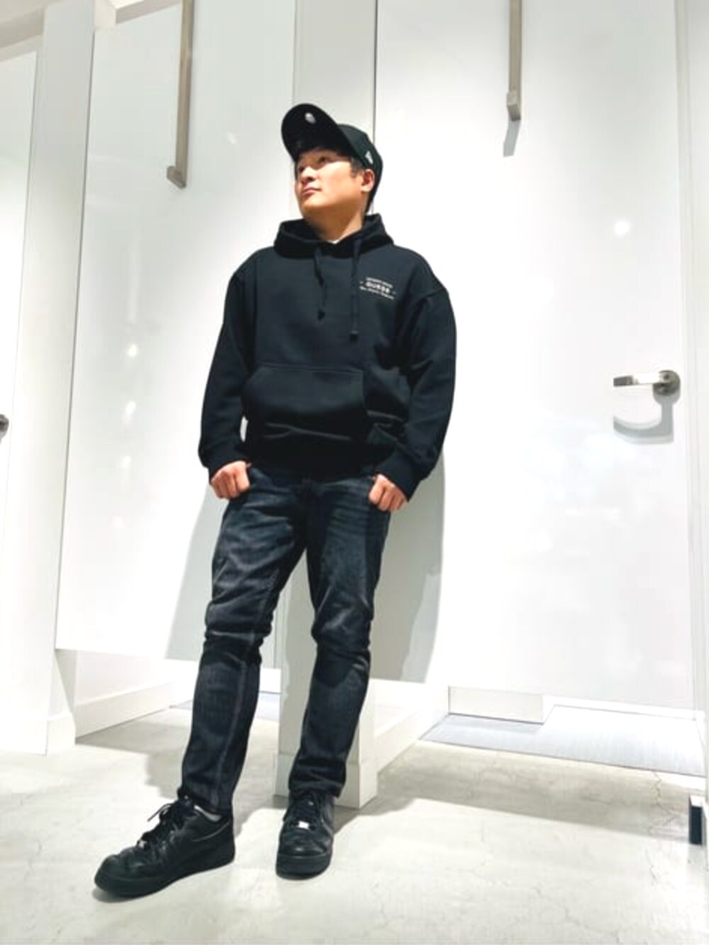 ブラック系のパーカー、グレー系のデニムパンツを着用したメンズの春コーディネートの1枚目の写真