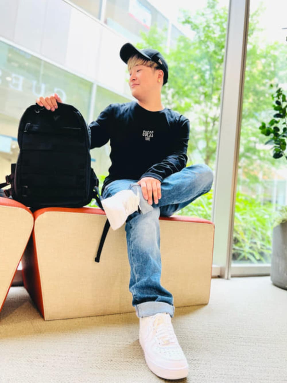 ブラック系のTシャツ/カットソー、ブルー系のデニムパンツ、ブラック系のバックパック/リュックを着用したメンズの冬コーディネートの1枚目の写真