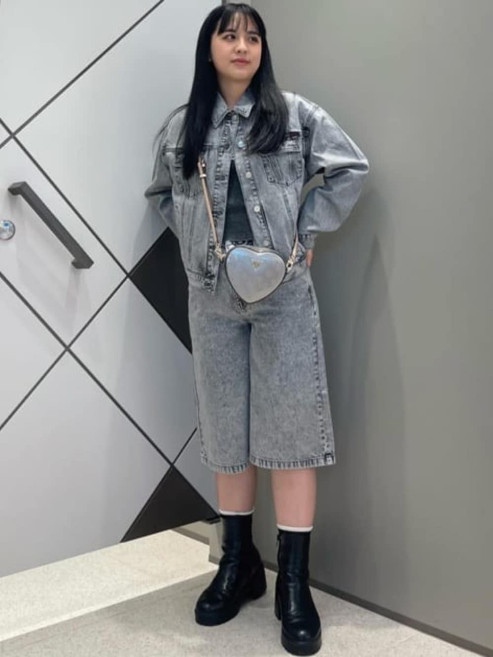 グレー系のショルダーバッグ、グレー系のタンクトップ、グレー系のデニムパンツを着用したレディースの夏コーディネートの1枚目の写真