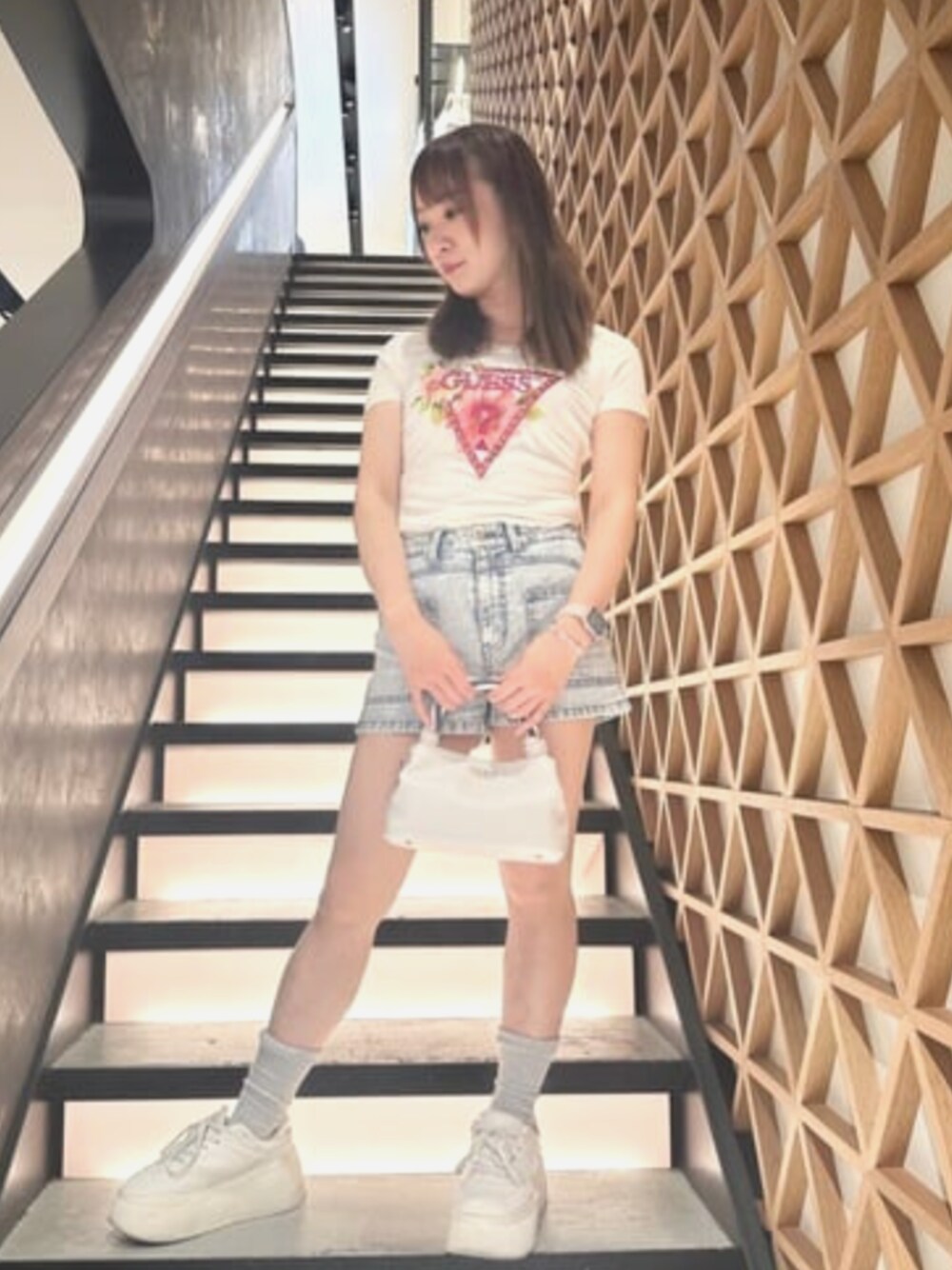 ベージュ系のTシャツ/カットソー、ブルー系のデニムパンツ、ホワイト系のショルダーバッグを着用したレディースの夏コーディネートの1枚目の写真