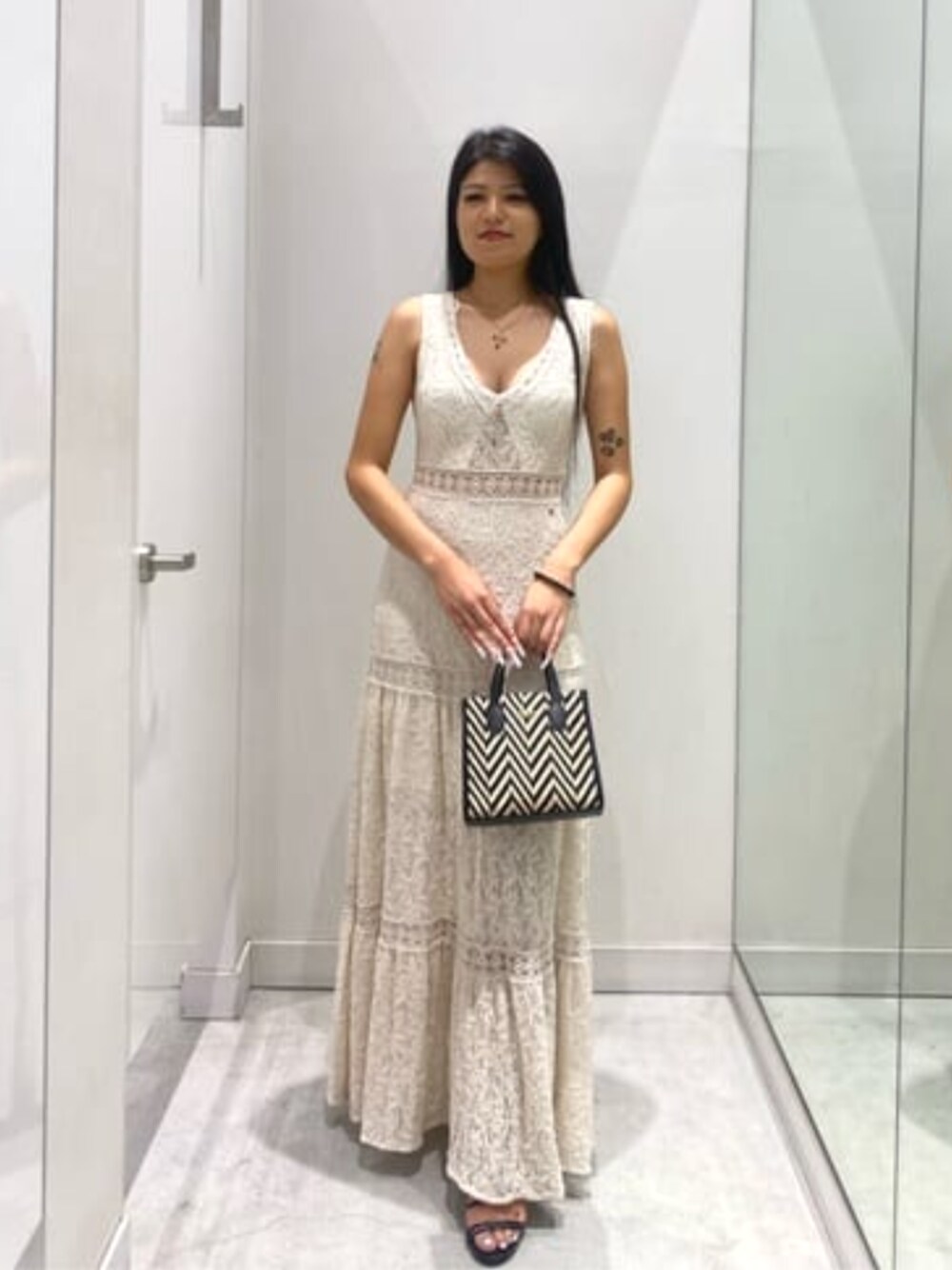 ベージュ系のワンピース、ブラック系のトートバッグを着用したレディースの夏コーディネートの1枚目の写真