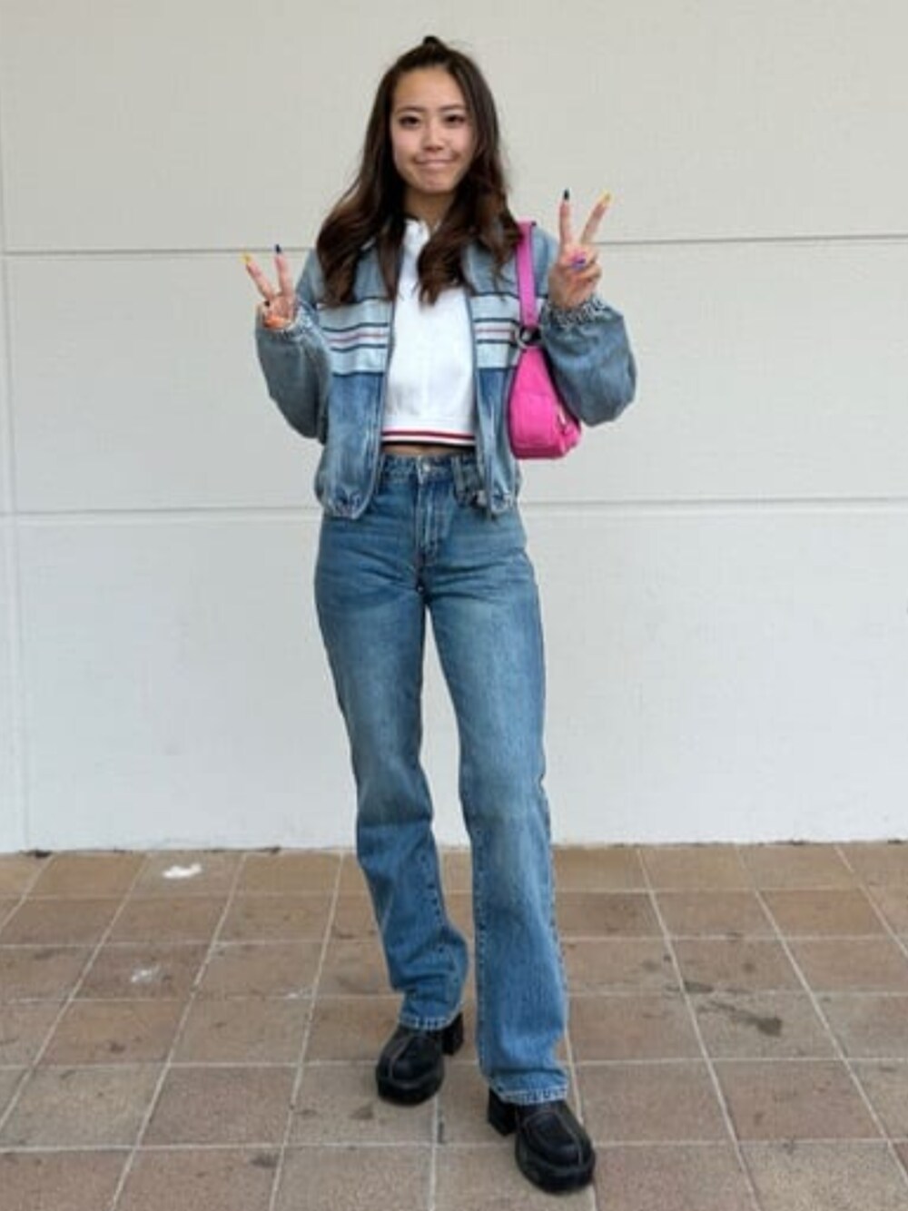 ブルー系のデニムパンツ、ブルー系のデニムジャケット、ホワイト系のポロシャツを着用したレディースの春コーディネートの1枚目の写真