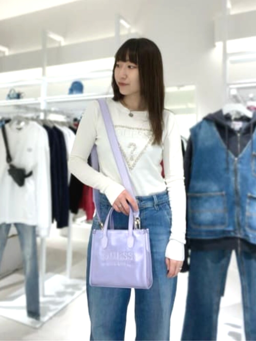 パープル系のショルダーバッグ、ベージュ系のニット/セーターを着用したレディースの春コーディネートの1枚目の写真