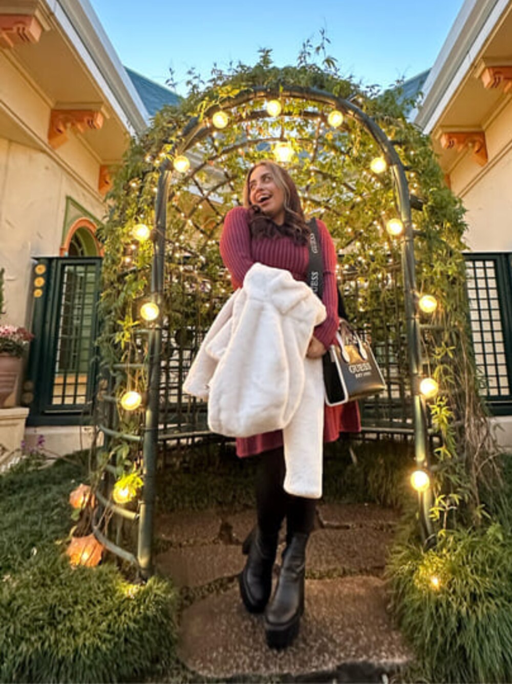 ベージュ系のその他アウター、ブラック系のトートバッグ、レッド系のワンピースを着用したレディースの冬コーディネートの1枚目の写真