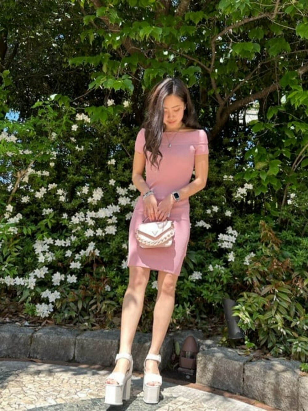 ピンク系のハンドバッグ、ピンク系のワンピースを着用したレディースの夏コーディネートの1枚目の写真