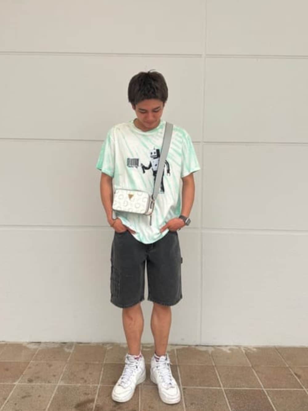 ブルー系のTシャツ/カットソー、ブラック系のデニムパンツ、ホワイト系のショルダーバッグを着用したメンズの夏コーディネートの1枚目の写真