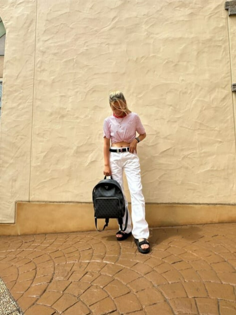 ブラック系のバックパック/リュック、ホワイト系のデニムパンツ、レッド系のTシャツ/カットソーを着用したレディースの秋コーディネートの1枚目の写真