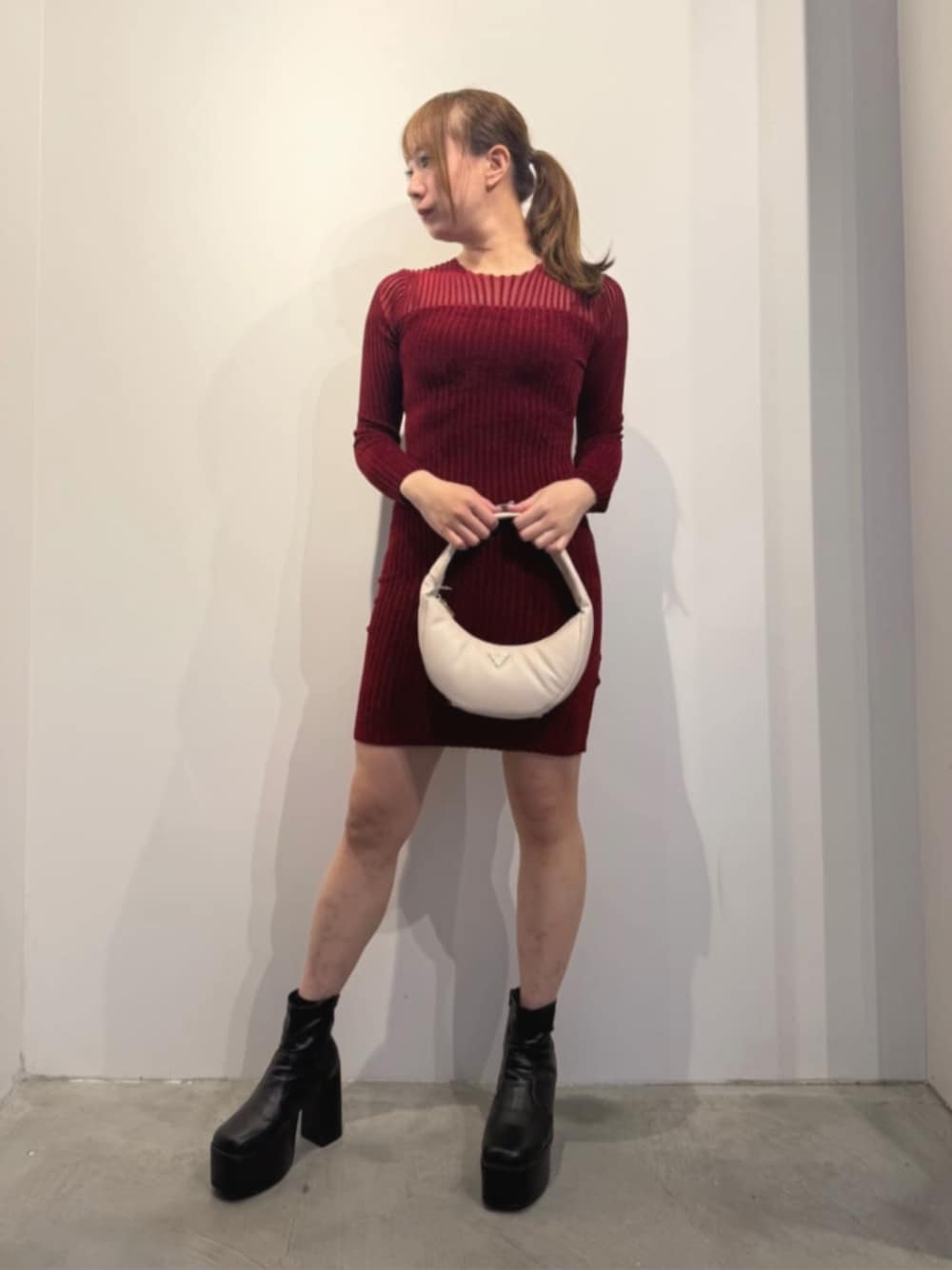 ホワイト系のショルダーバッグ、レッド系のワンピースを着用したレディースの冬コーディネートの1枚目の写真