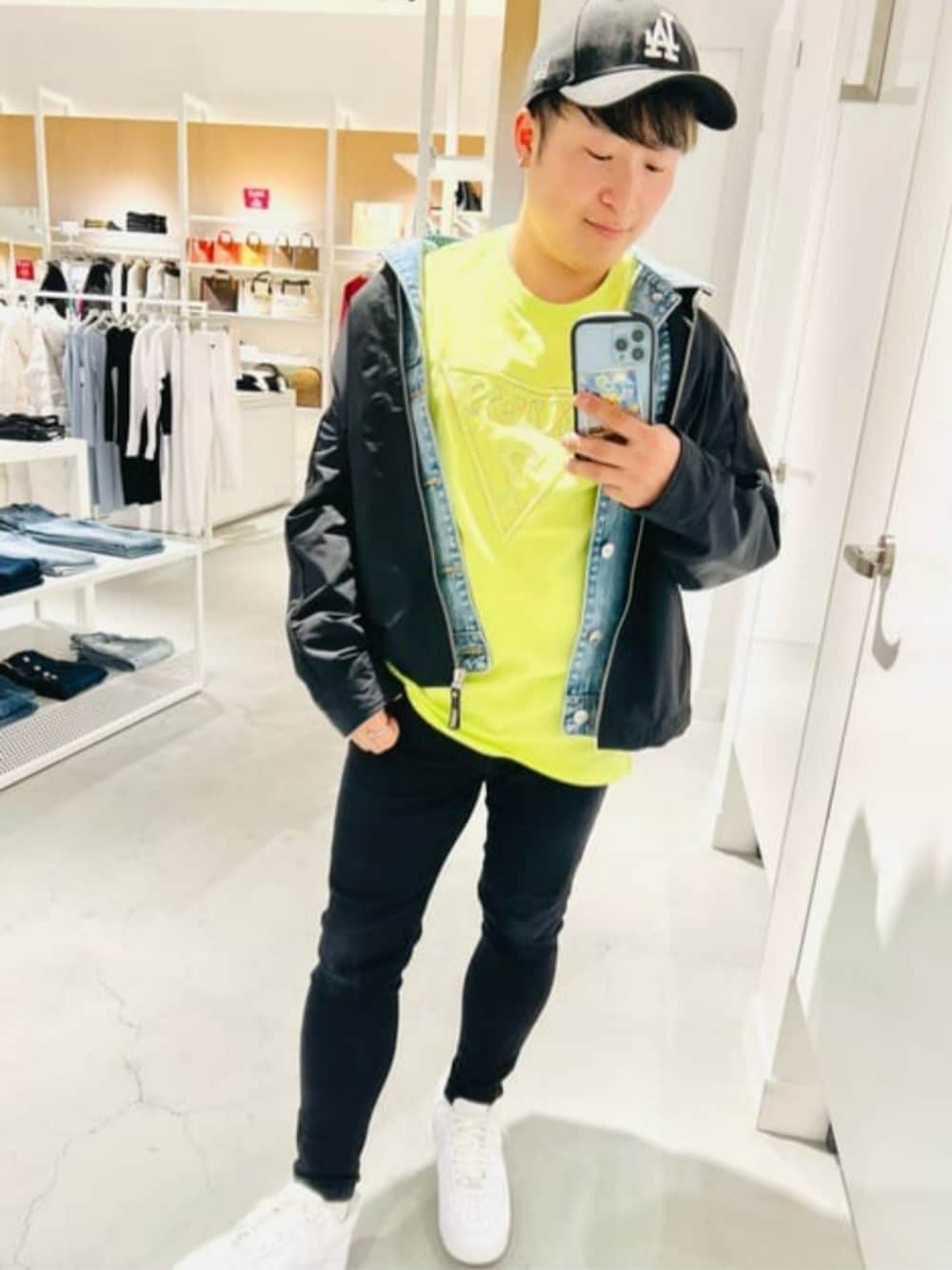 ブラック系のデニムパンツ、ブラック系のブルゾン、グリーン系のTシャツ/カットソーを着用したメンズの夏コーディネートの1枚目の写真