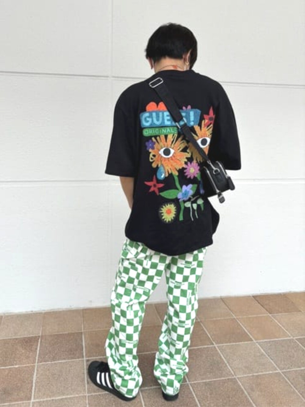 ブラック系のTシャツ/カットソー、グリーン系のデニムパンツ、ブラック系のショルダーバッグを着用したメンズの春コーディネートの1枚目の写真