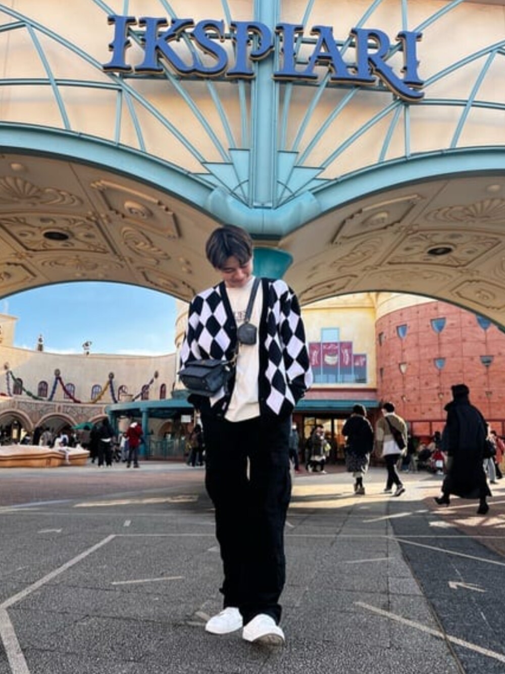 ブラック系のカーディガン/ボレロ、ホワイト系のTシャツ/カットソー、ブラック系のカーゴパンツを着用したメンズの冬コーディネートの1枚目の写真