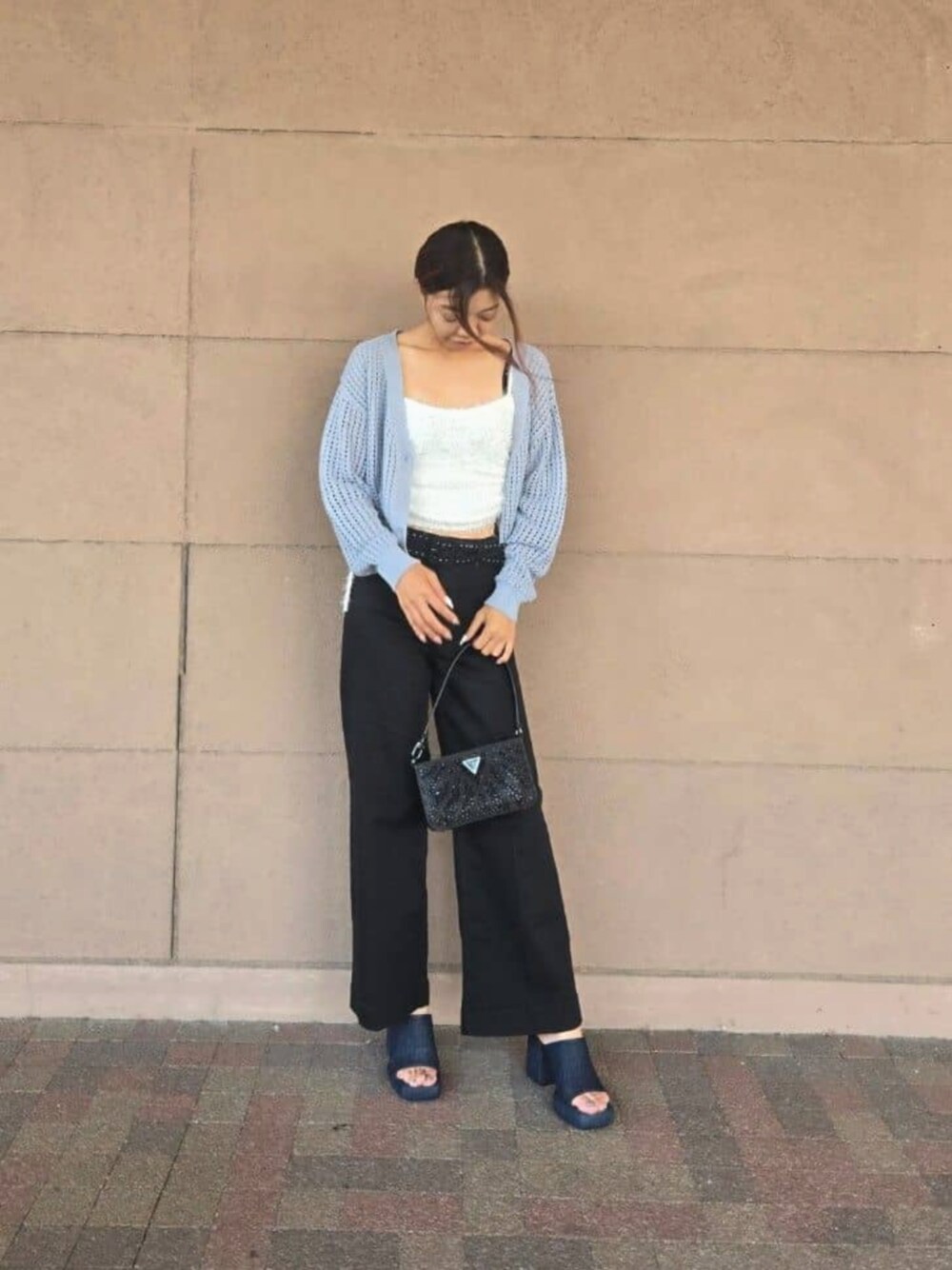 ブラック系のデニムパンツ、ブルー系のカーディガン/ボレロ、その他のキャミソールを着用したレディースの秋コーディネートの1枚目の写真