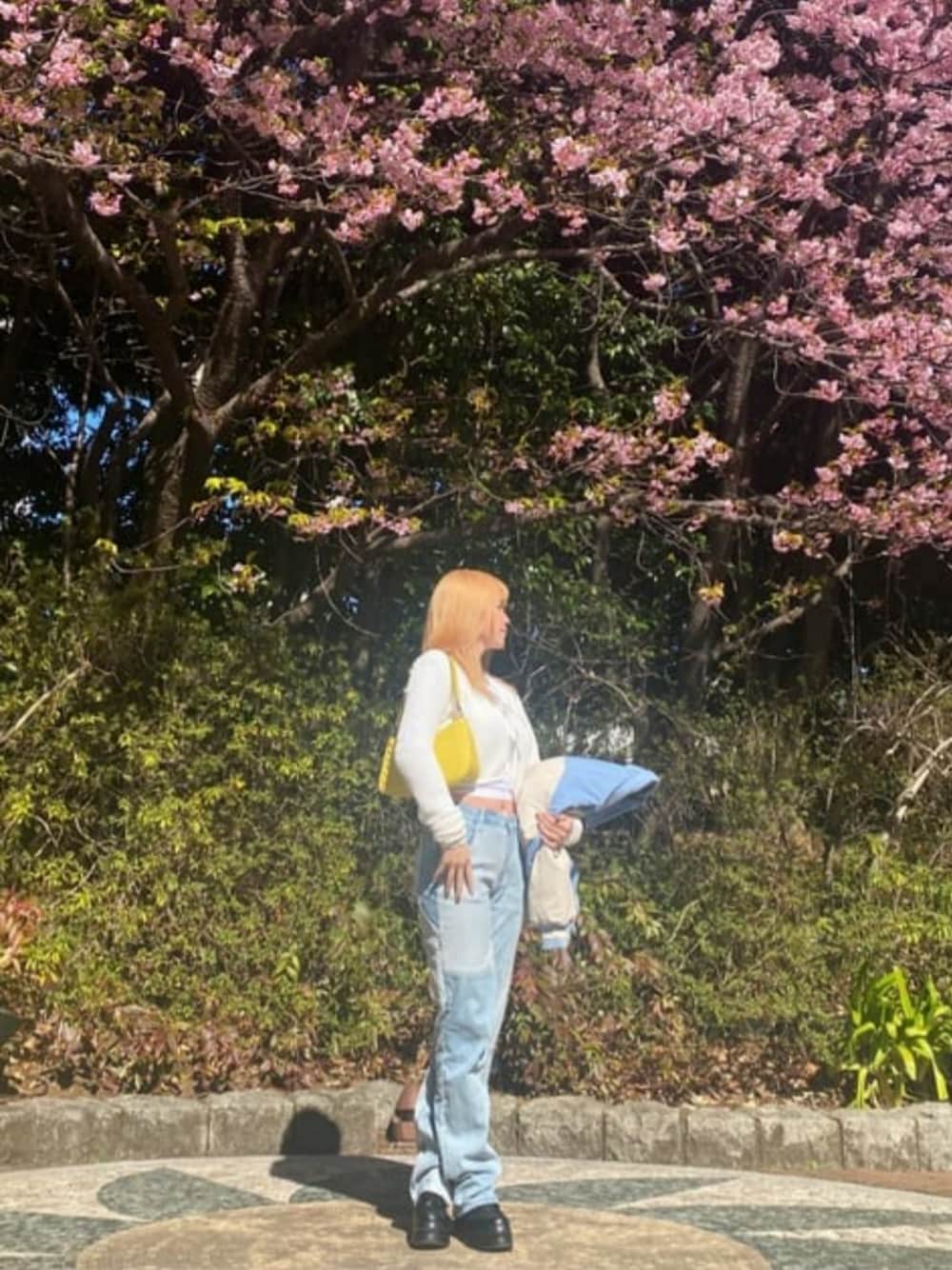 ブルー系のデニムパンツ、イエロー系のショルダーバッグ、ブルー系のスタジャンを着用したレディースの夏コーディネートの1枚目の写真