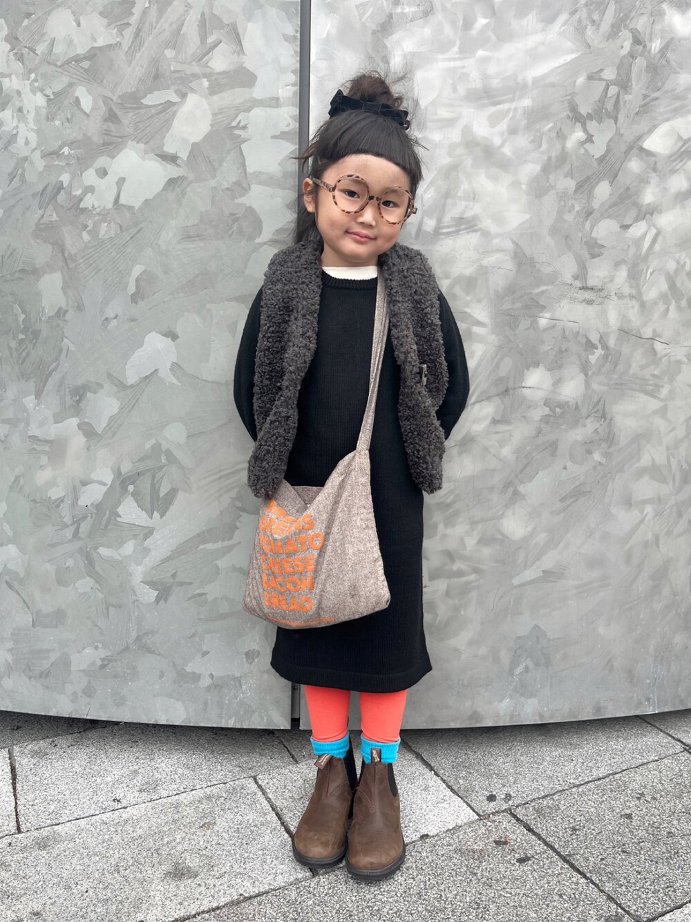 ブラック系のワンピース、グレー系のベスト、ホワイト系のTシャツ/カットソーを着用したキッズの冬コーディネートの1枚目の写真