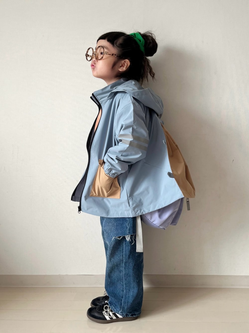 ブルー系のナイロンジャケット、オレンジ系のニット/セーター、ブルー系のデニムパンツを着用したキッズの秋コーディネートの1枚目の写真