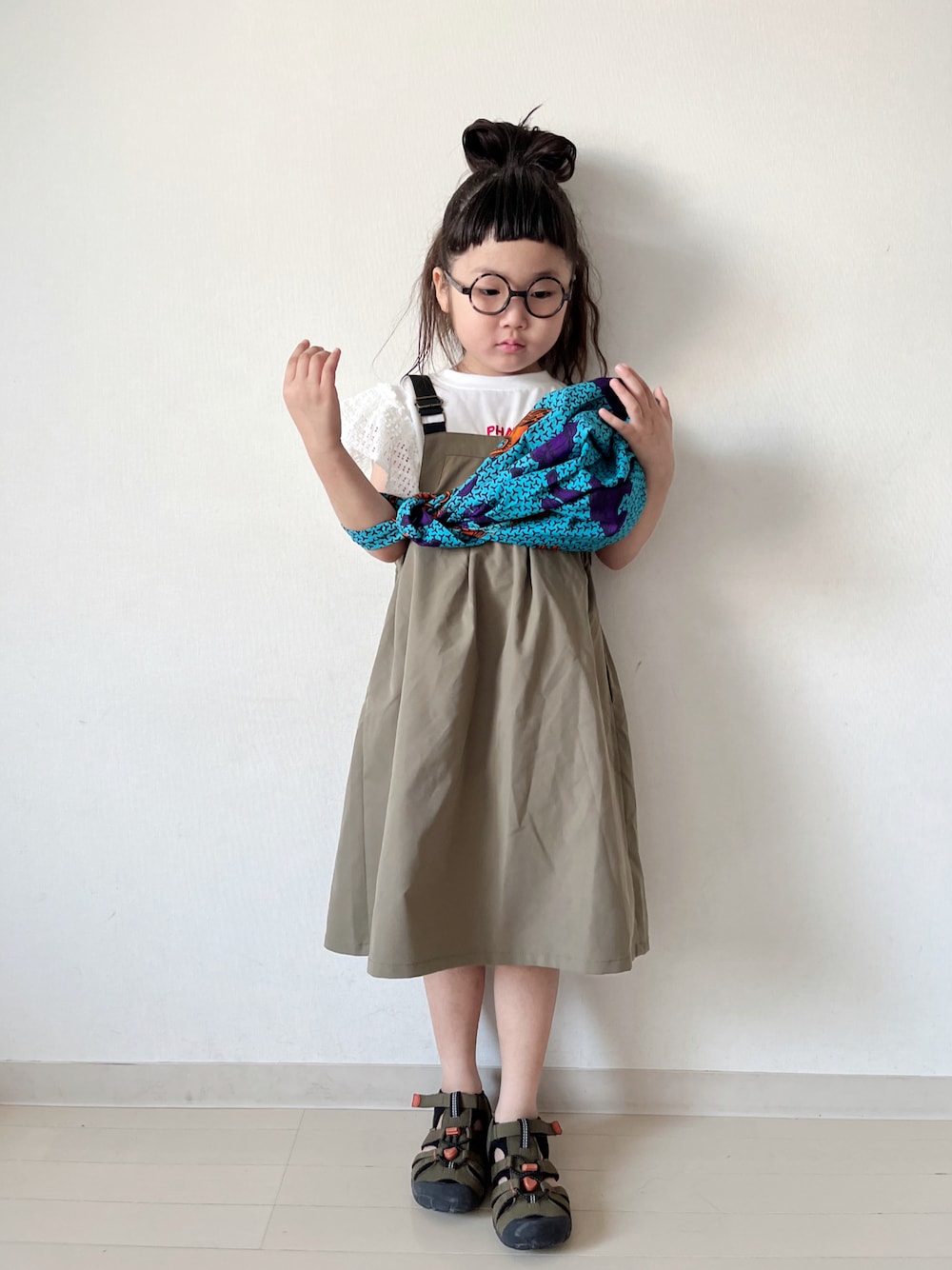 グリーン系のワンピース、ブルー系のハンドバッグ、グリーン系のサンダルを着用したキッズの夏コーディネートの1枚目の写真