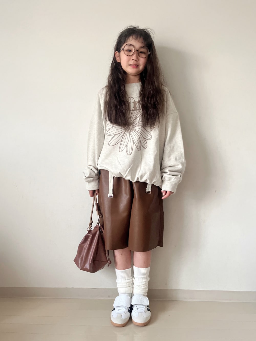 ベージュ系のスウェット、グリーン系のTシャツ/カットソー、ブラウン系のショルダーバッグを着用したキッズの秋コーディネートの1枚目の写真