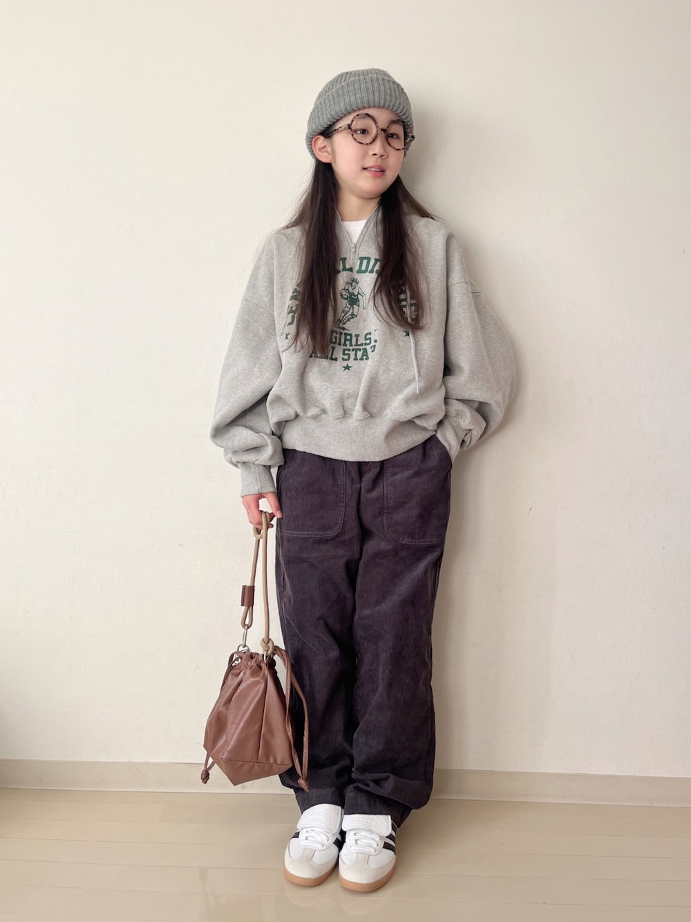 グレー系のスウェット、グレー系のその他パンツ、ブラウン系のショルダーバッグを着用したキッズの冬コーディネートの1枚目の写真