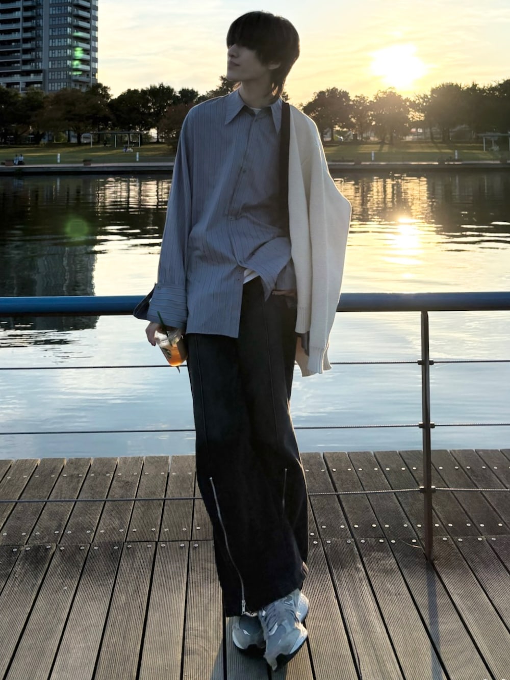 ブラック系のデニムパンツ、ホワイト系のTシャツ/カットソー、グレー系のスニーカーを着用したメンズの秋コーディネートの1枚目の写真