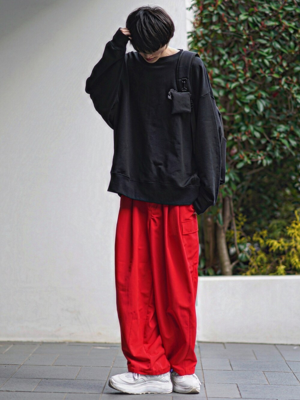 ブラック系のスウェット、レッド系のカーゴパンツ、ホワイト系のスニーカーを着用したメンズの春コーディネートの1枚目の写真
