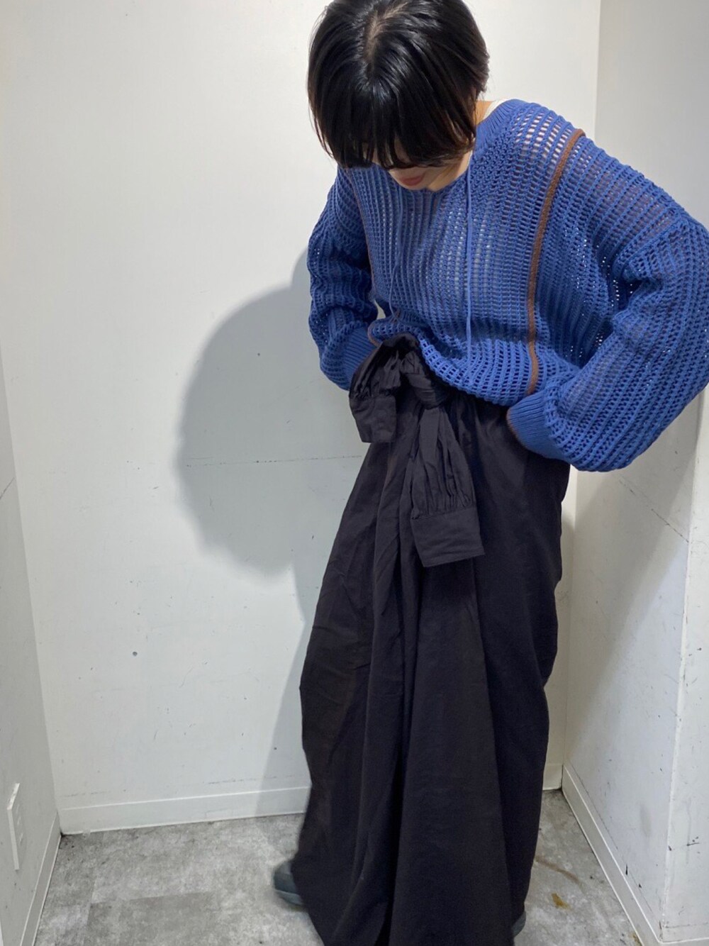 ブルー系のニット/セーター、ブラック系のワンピース、ブラック系のスニーカーを着用したレディースの秋コーディネートの1枚目の写真