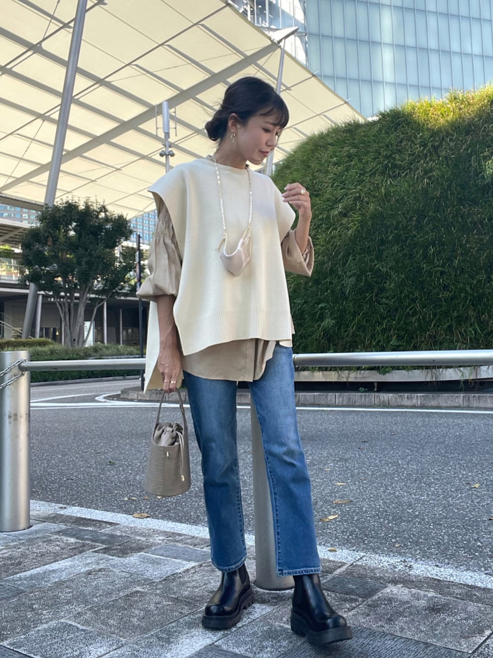 ホワイト系のベスト、ベージュ系のシャツ/ブラウス、ブルー系のデニムパンツを着用したレディースの秋コーディネートの1枚目の写真