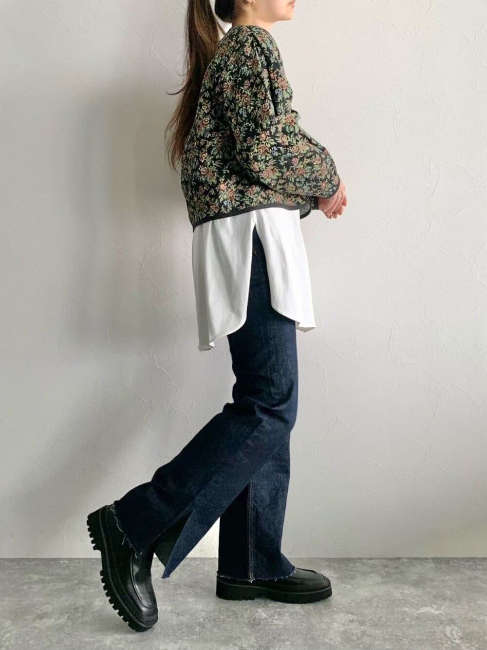 ブルー系のデニムパンツ、ホワイト系のTシャツ/カットソー、ブラック系のカーディガン/ボレロを着用したレディースの冬コーディネートの2枚目の写真