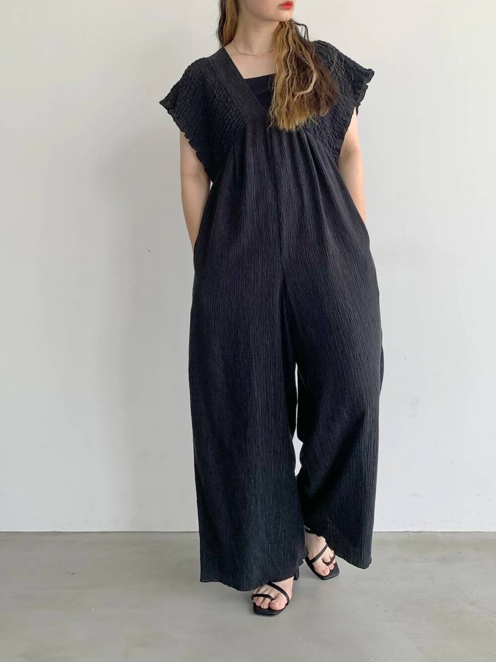 ブラック系のサロペット/オーバーオール、ブラック系のサンダル、レッド系のキャップを着用したレディースの夏コーディネートの1枚目の写真