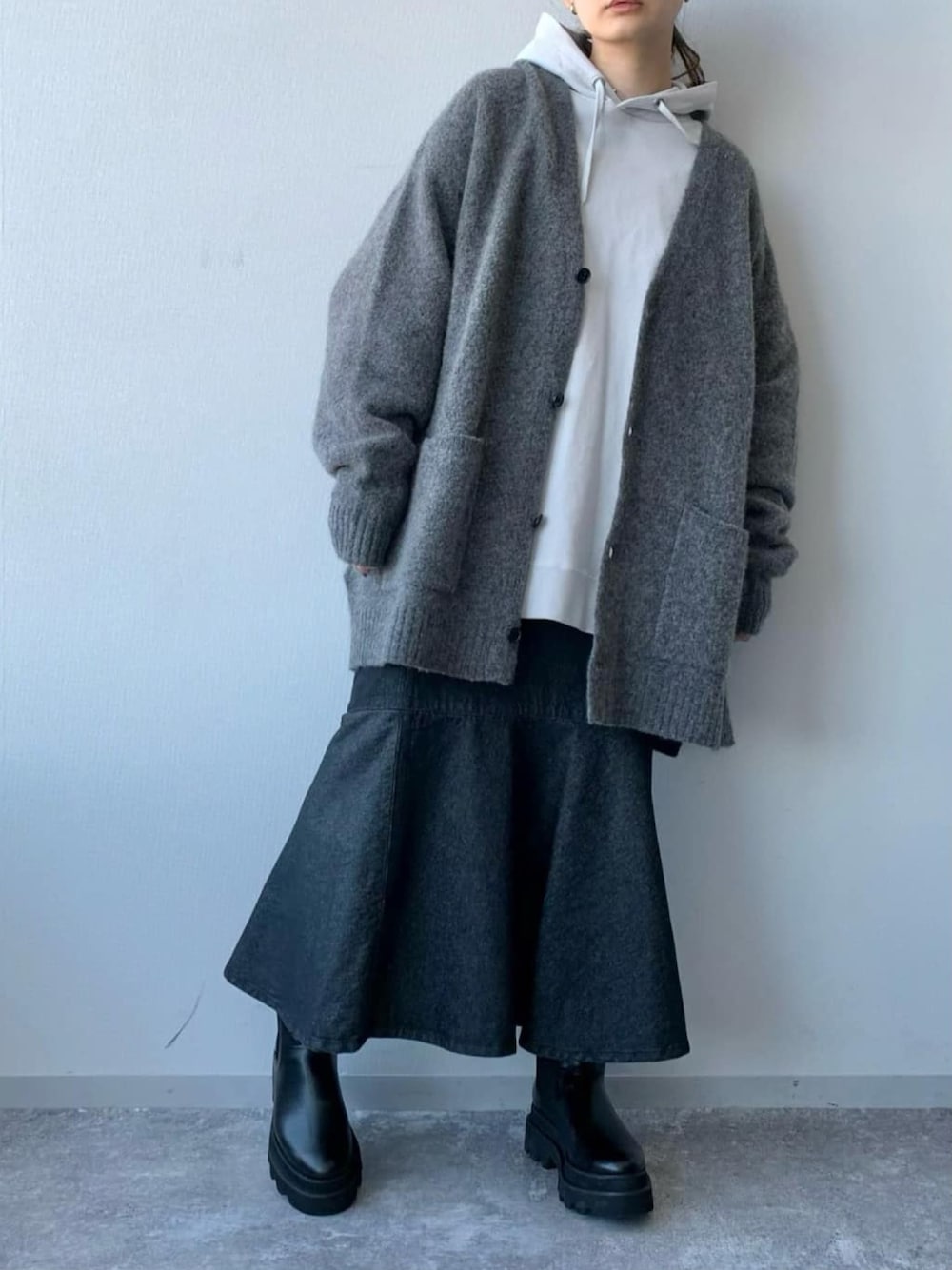 ブルー系のスカート、ブラック系のブーツ、グレー系のカーディガン/ボレロを着用したレディースの冬コーディネートの3枚目の写真
