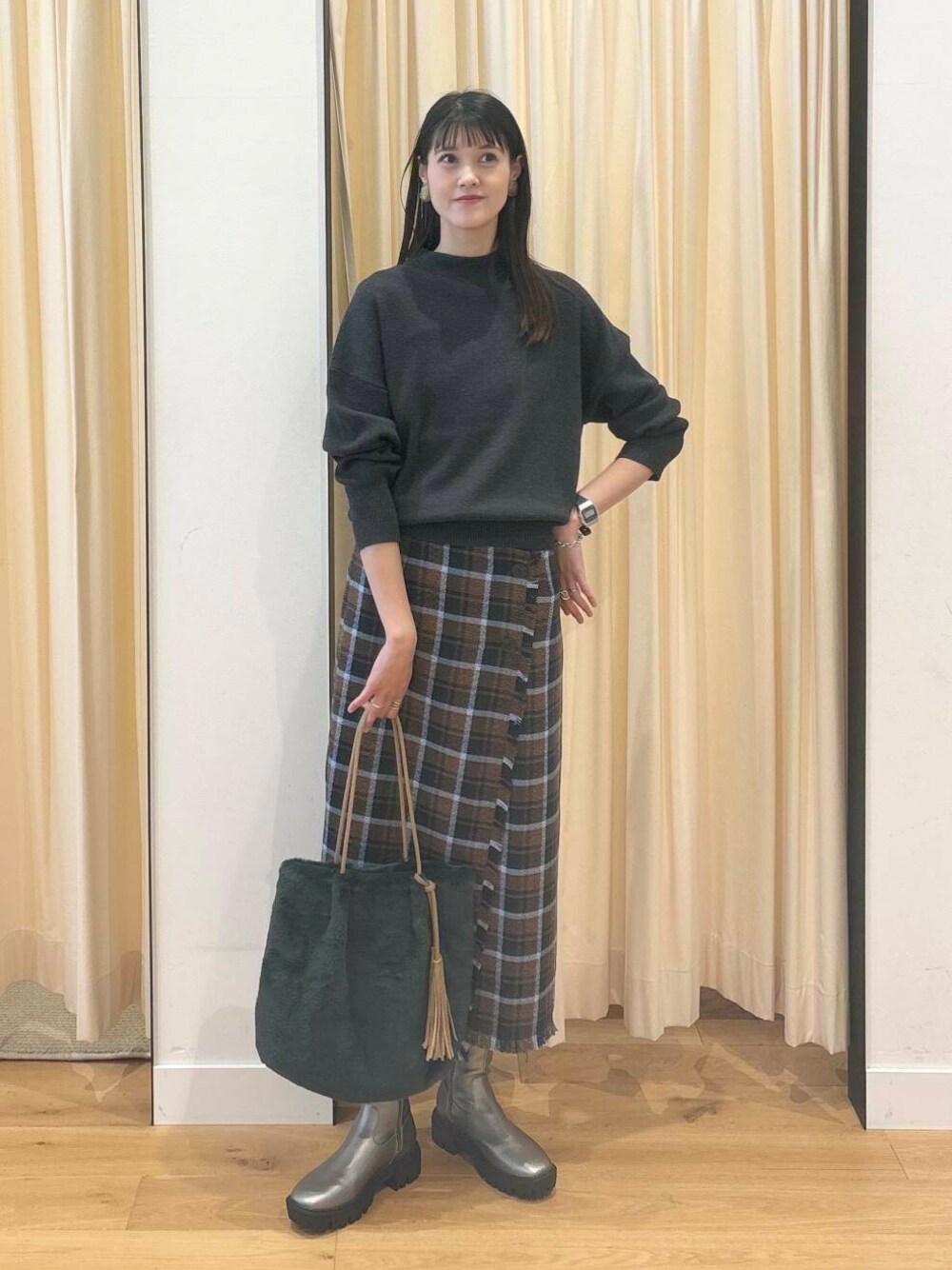 グレー系のニット/セーター、シルバー系のブーツ、ブラウン系のスカートを着用したレディースの秋コーディネートの1枚目の写真