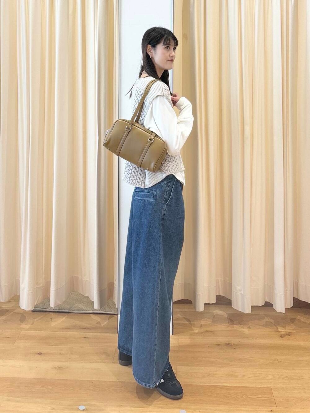 ホワイト系のTシャツ/カットソー、グリーン系のボストンバッグ、ブラック系のスニーカーを着用したレディースの秋コーディネートの1枚目の写真