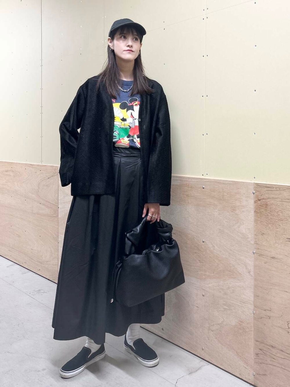 ブラック系のハンドバッグ、ブラック系のスカート、ブラック系のカーディガン/ボレロを着用したレディースの秋コーディネートの1枚目の写真