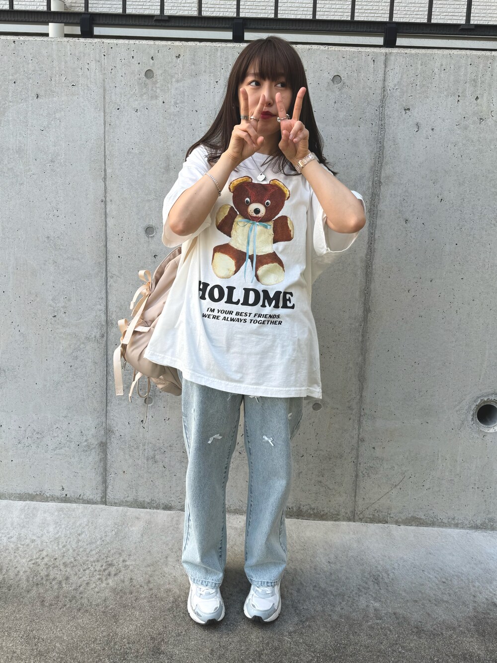 ブルー系のデニムパンツ、ホワイト系のTシャツ/カットソー、ベージュ系のバックパック/リュックを着用したレディースの夏コーディネートの1枚目の写真