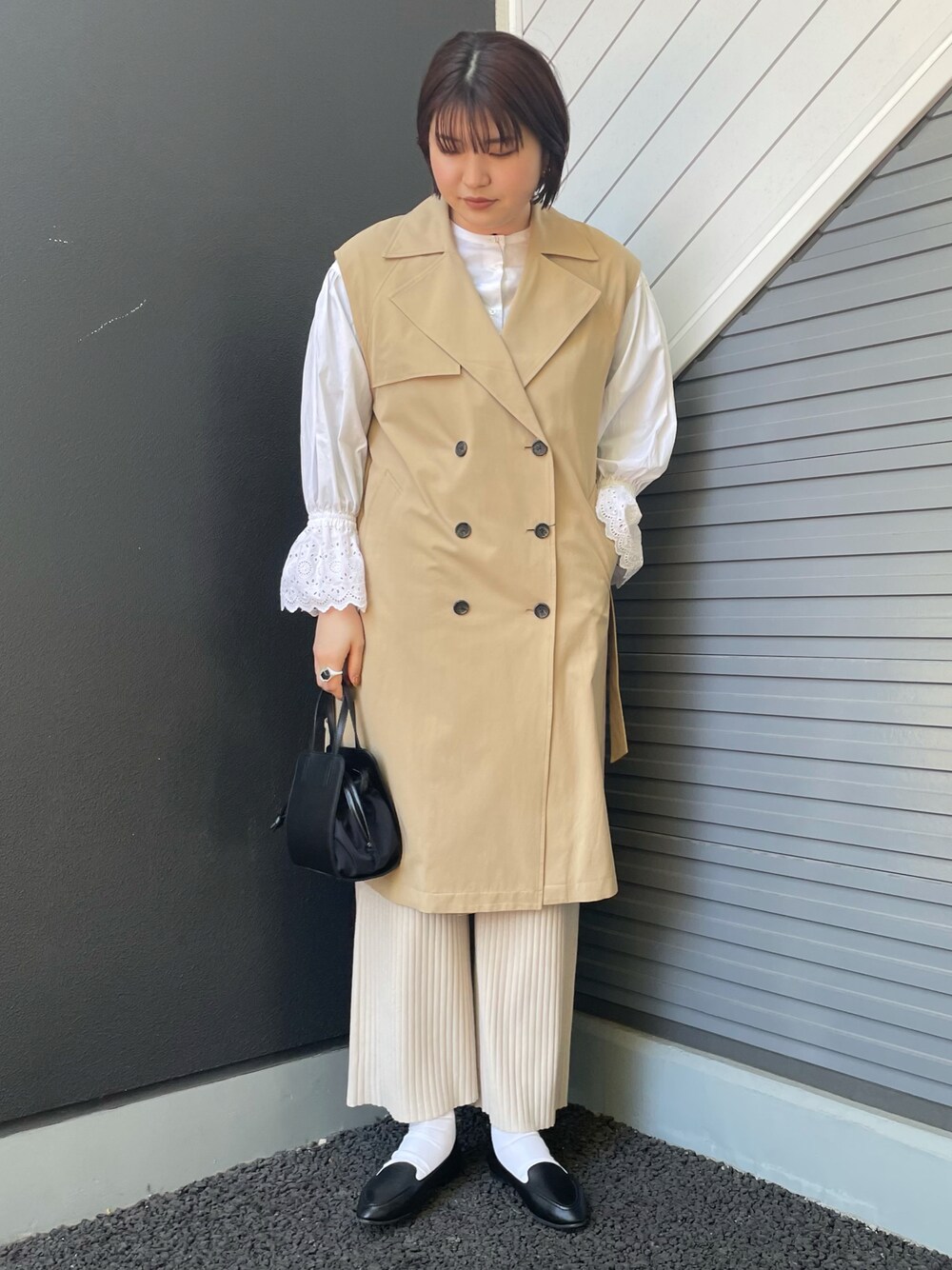 ベージュ系のベスト、ホワイト系のシャツ/ブラウス、ブラック系のショルダーバッグを着用したレディースの冬コーディネートの1枚目の写真