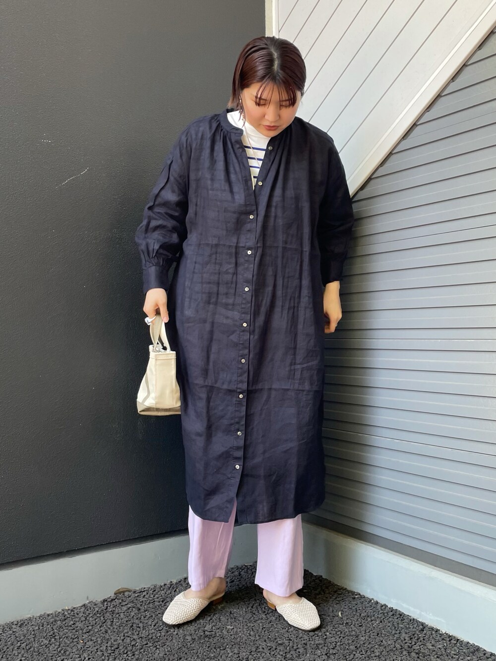 ブルー系のワンピース、ベージュ系のハンドバッグ、ブルー系のTシャツ/カットソーを着用したレディースの春コーディネートの1枚目の写真