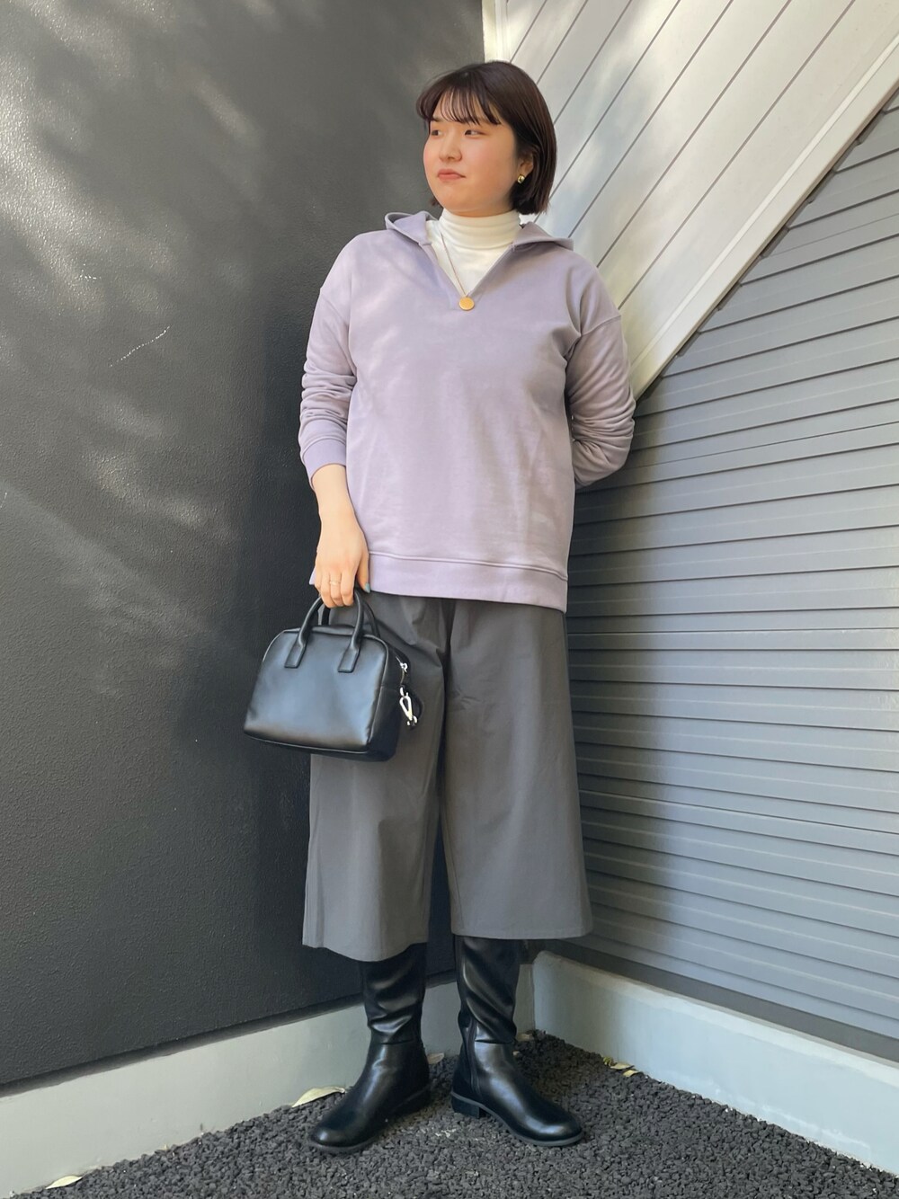 パープル系のパーカー、ホワイト系のTシャツ/カットソー、ブラック系のボストンバッグを着用したレディースの冬コーディネートの1枚目の写真