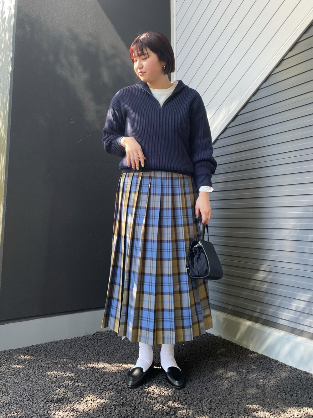 ブルー系のニット/セーター、ブルー系のスカート、ブラック系のショルダーバッグを着用したレディースの冬コーディネートの1枚目の写真