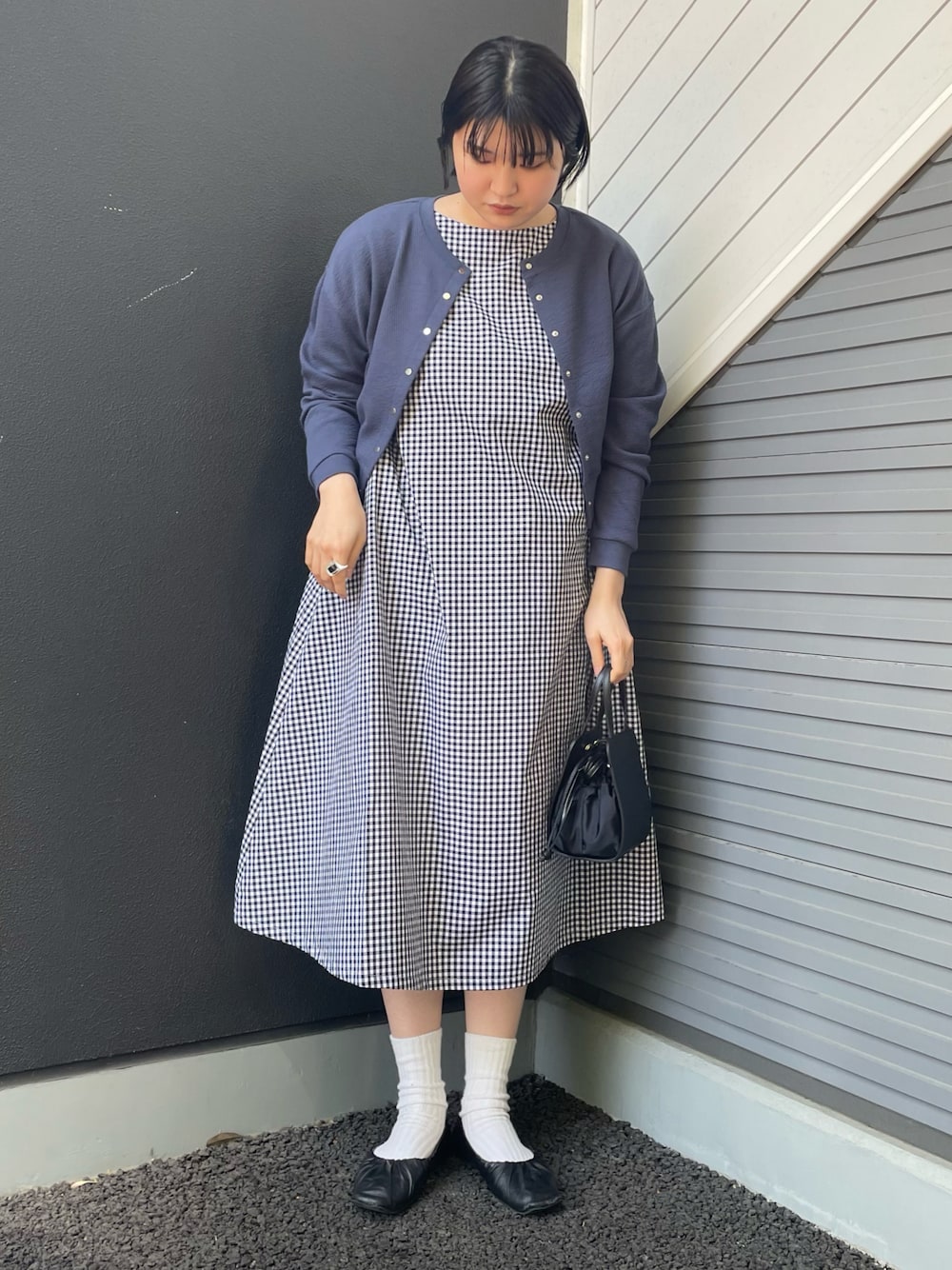 ブラック系のワンピース、ブルー系のカーディガン/ボレロ、ブラック系のショルダーバッグを着用したレディースの春コーディネートの1枚目の写真