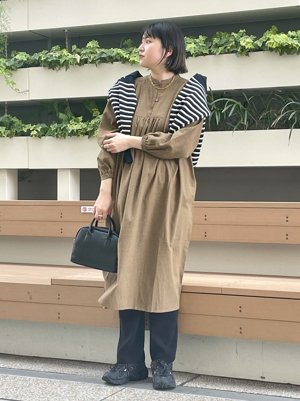 ブルー系のカーディガン/ボレロ、ベージュ系のワンピース、ブラック系のボストンバッグを着用したレディースの秋コーディネートの1枚目の写真