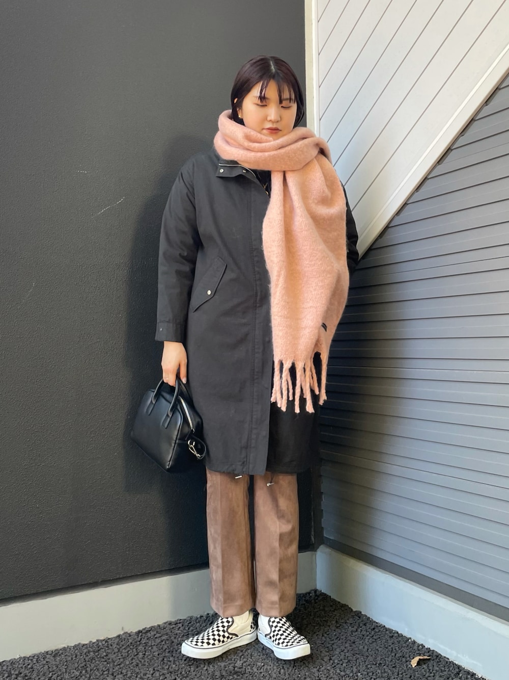 ブラック系のミリタリージャケット、ブラック系のボストンバッグ、ブラウン系のその他パンツを着用したレディースの冬コーディネートの1枚目の写真