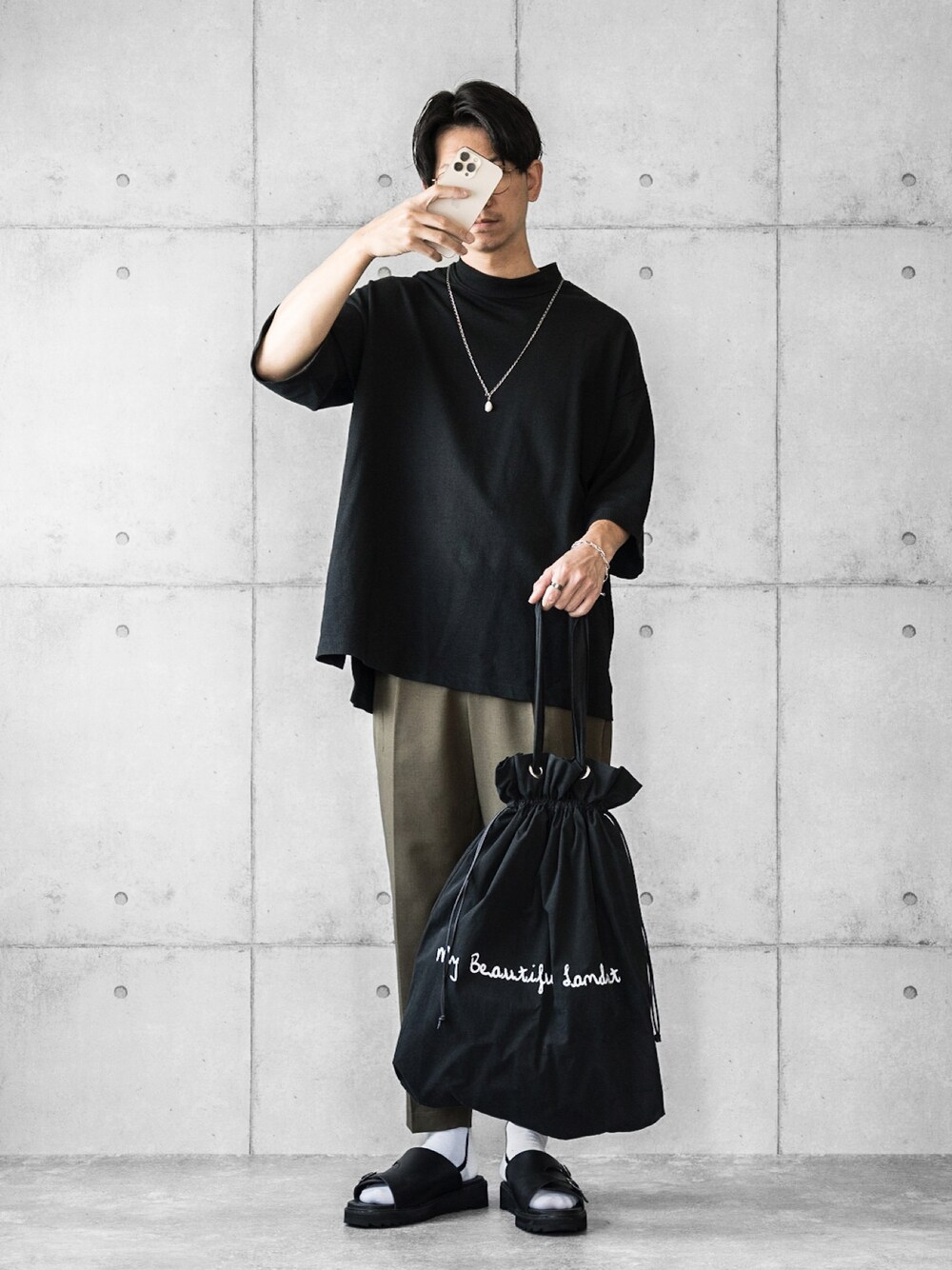 ブラック系のTシャツ/カットソー、グリーン系のパンツ、ブラック系のサンダルを着用したメンズの夏コーディネートの1枚目の写真