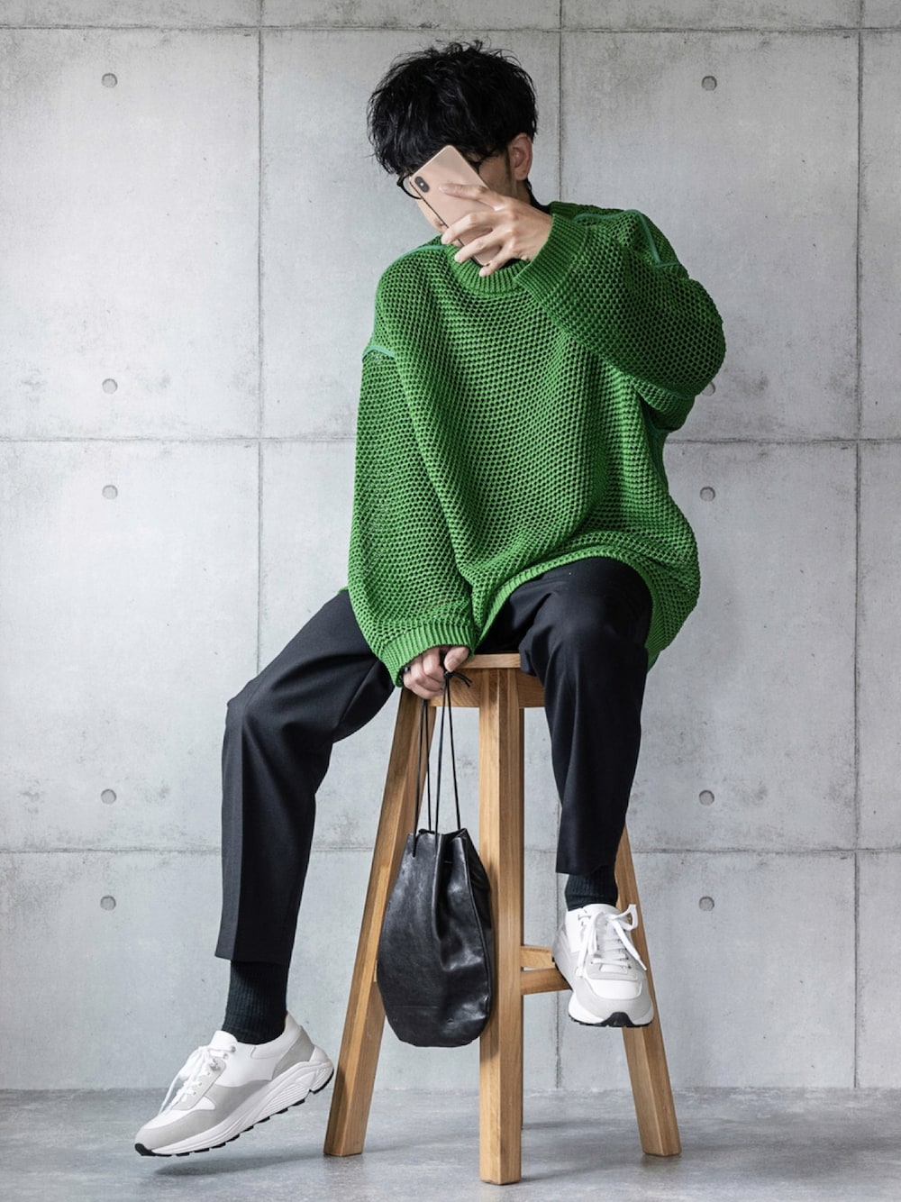 グリーン系のニット/セーター、ブラック系のスラックス、ブラック系のショルダーバッグを着用したメンズの秋コーディネートの1枚目の写真
