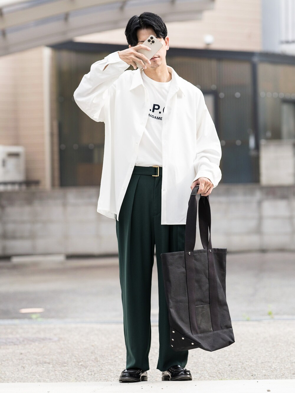 ホワイト系のTシャツ/カットソー、グリーン系のスラックス、ブラック系のトートバッグを着用したメンズの夏コーディネートの1枚目の写真