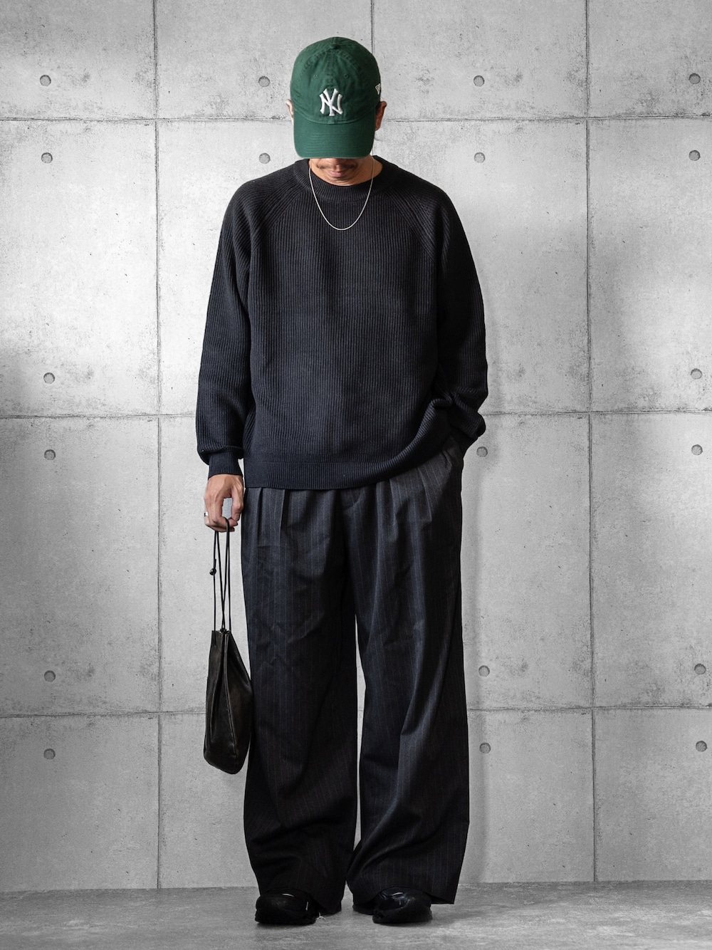 ブラック系のショルダーバッグ、グレー系のニット/セーター、グレー系のスラックスを着用したメンズの秋コーディネートの1枚目の写真