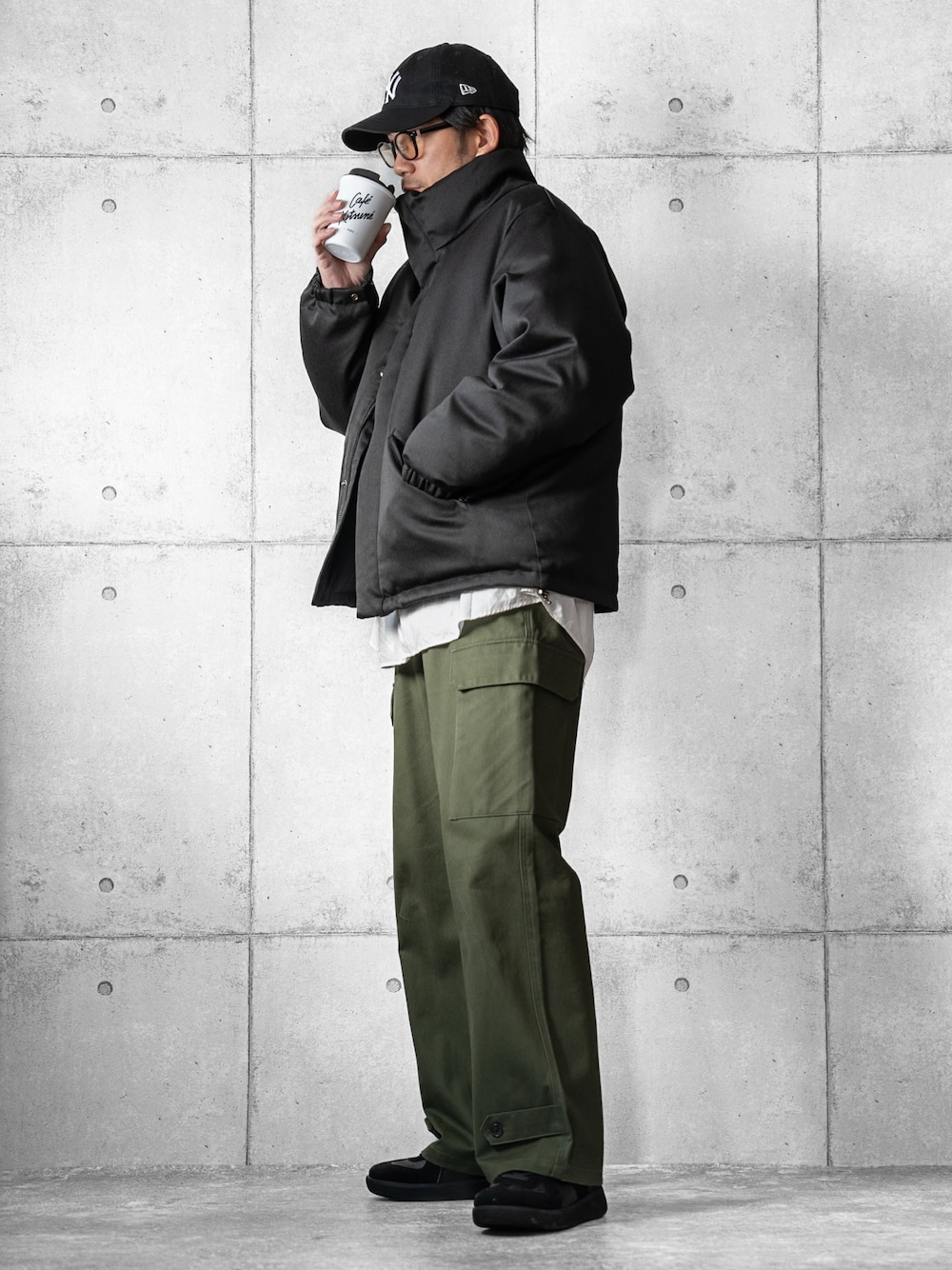 ブラック系のスニーカー、ブラック系のダウンジャケット/コート、グリーン系のカーゴパンツを着用したメンズの冬コーディネートの1枚目の写真