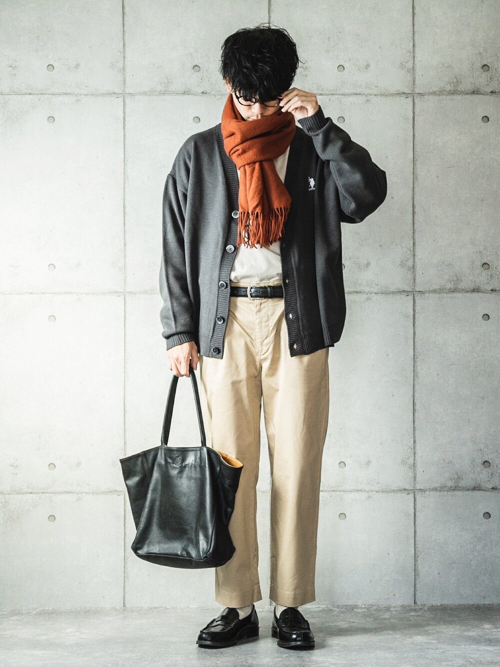 グレー系のカーディガン/ボレロ、ベージュ系のチノパンツ、ブラック系のトートバッグを着用したメンズの秋コーディネートの1枚目の写真
